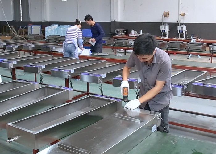 Workers assembling stainless steel commercial kitchen equipment in the Tarzan Kitchen factory