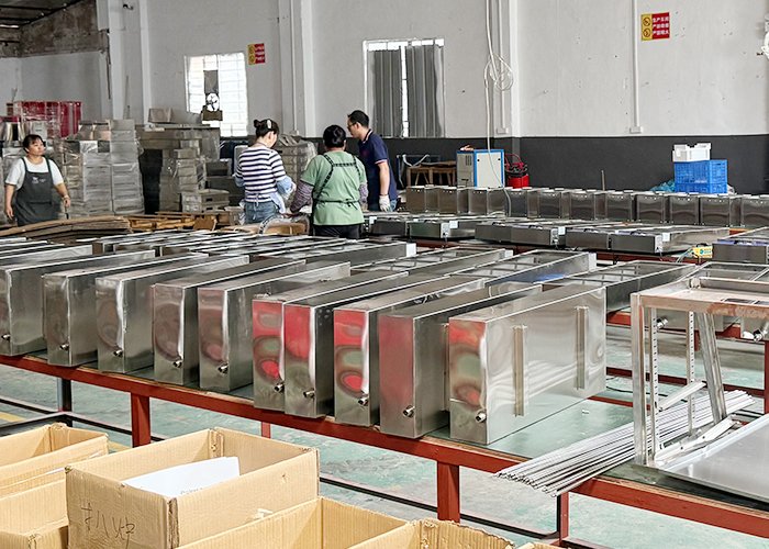 Tarzan Kitchen production team inspecting stainless steel commercial kitchen equipment before shipment