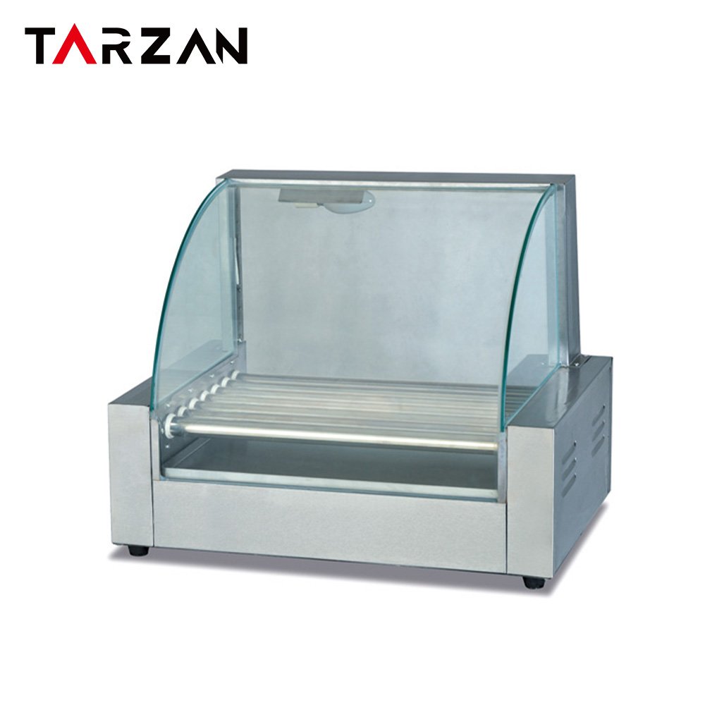 Angled view of a sausage roller grill with the glass sneeze guard lifted and the drip pan visible beneath the rollers.